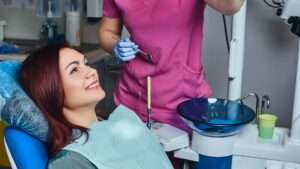 A young redhead woman having examination while sitting in a dental chair in the clinic. A young redhead woman having examination while sitting in a dental chair in the clinic.