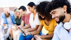 Group of young people using mobile phone in city street Group of young people using mobile phone in city street